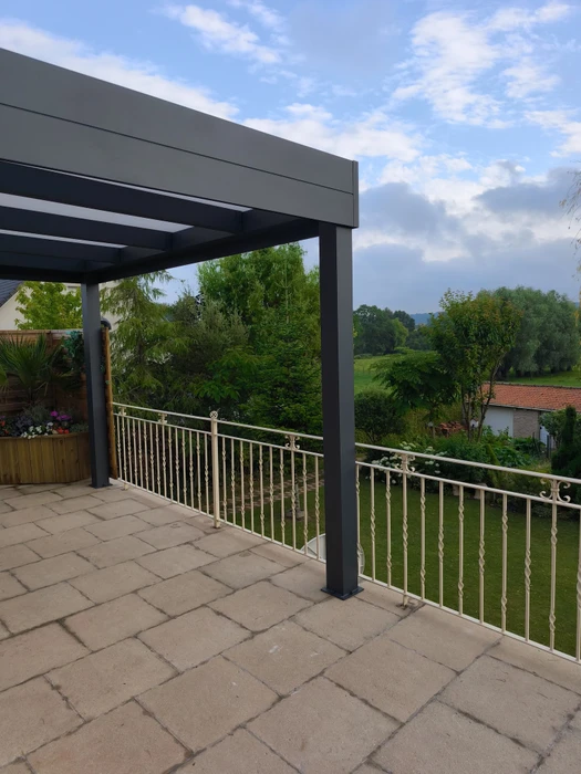 Terrasse extérieure avec pergola bioclimatique en aluminium anthracite, toiture à lames orientables