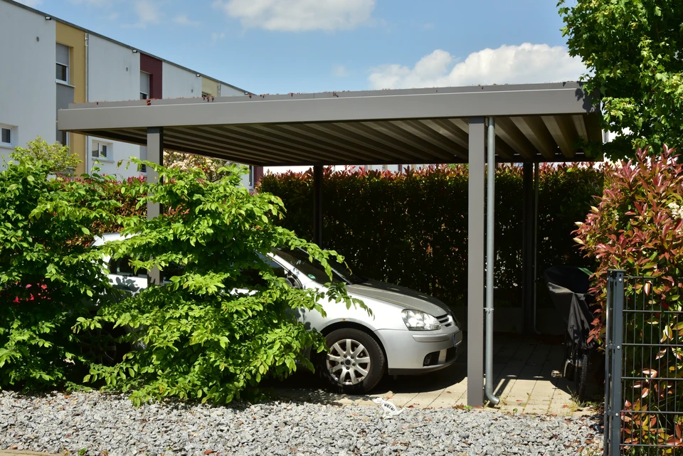Jardin paysager avec pergola m&eacute;tallique arqu&eacute;e supportant des rosiers grimpants aux fleurs blanches et roses