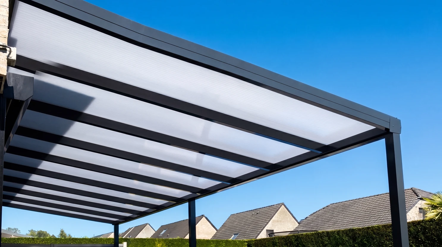Pergola bioclimatique en aluminium anthracite avec toiture en polycarbonate alv&eacute;olaire translucide, mont&eacute;e sur poteaux carr&eacute;s