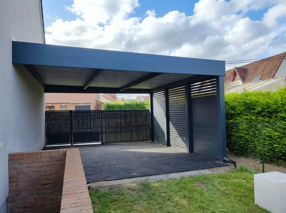 Garage moderne en métal de couleur anthracite, adossé à un mur en briques rouges