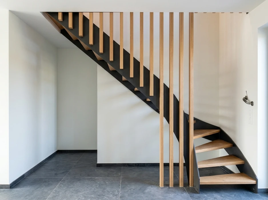Escalier flottant en cours d'installation dans un intérieur brut de chantier