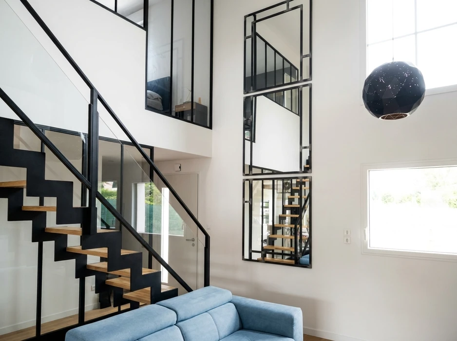 Escalier design intérieur à structure métallique noire (limon central en acier), marches en bois massif type hêtre, sans contremarches (escalier à marches flottantes)