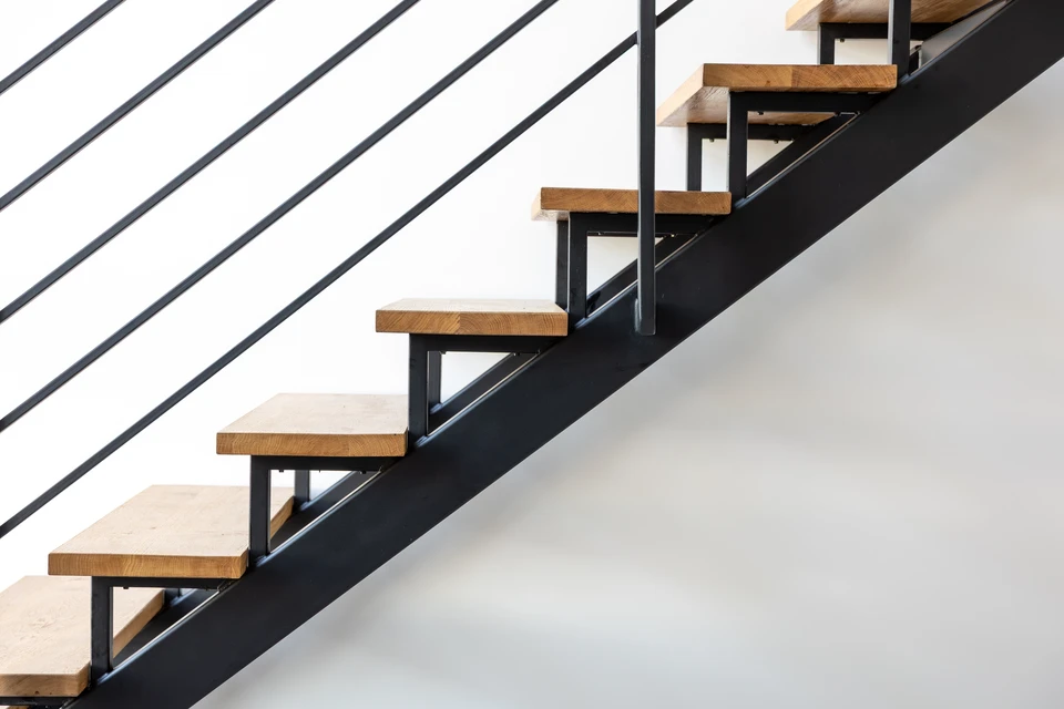 Intérieur résidentiel contemporain avec escalier flottant en bois clair à structure métallique noire